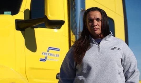a woman in front of a yellow truck