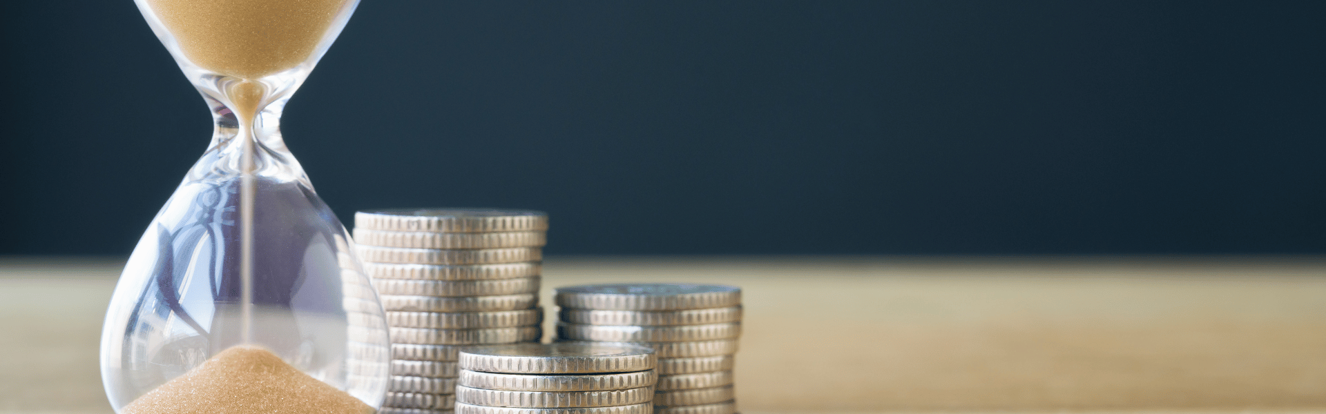 coins on table next to hourglass