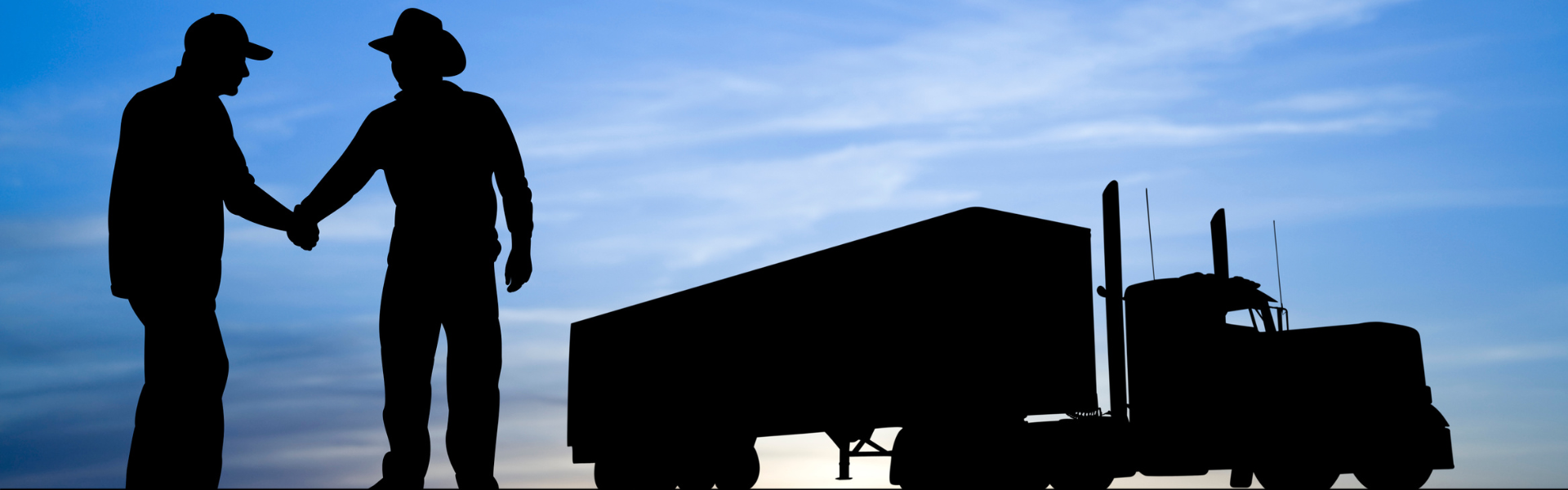 silhouettes of two men and a semi truck