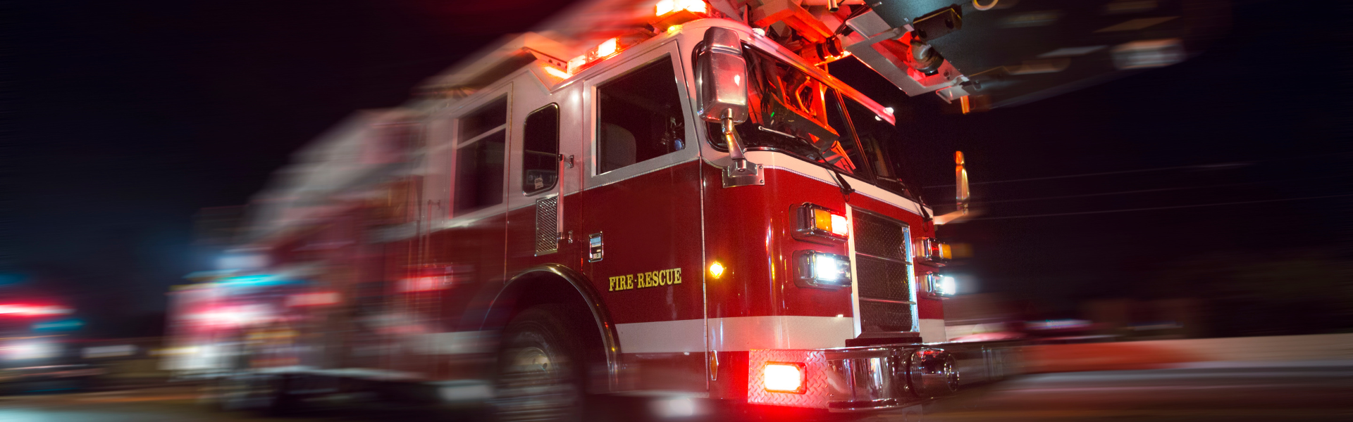 Fire truck with lights on driving down the road