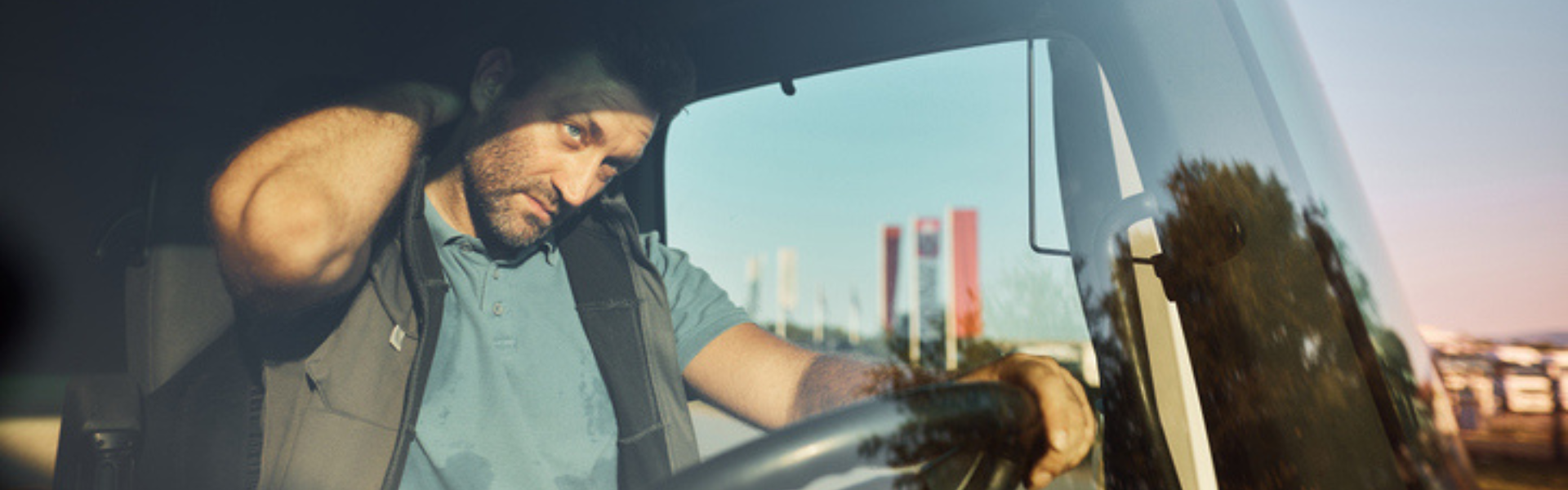 man driving a semi truck rubbing his neck