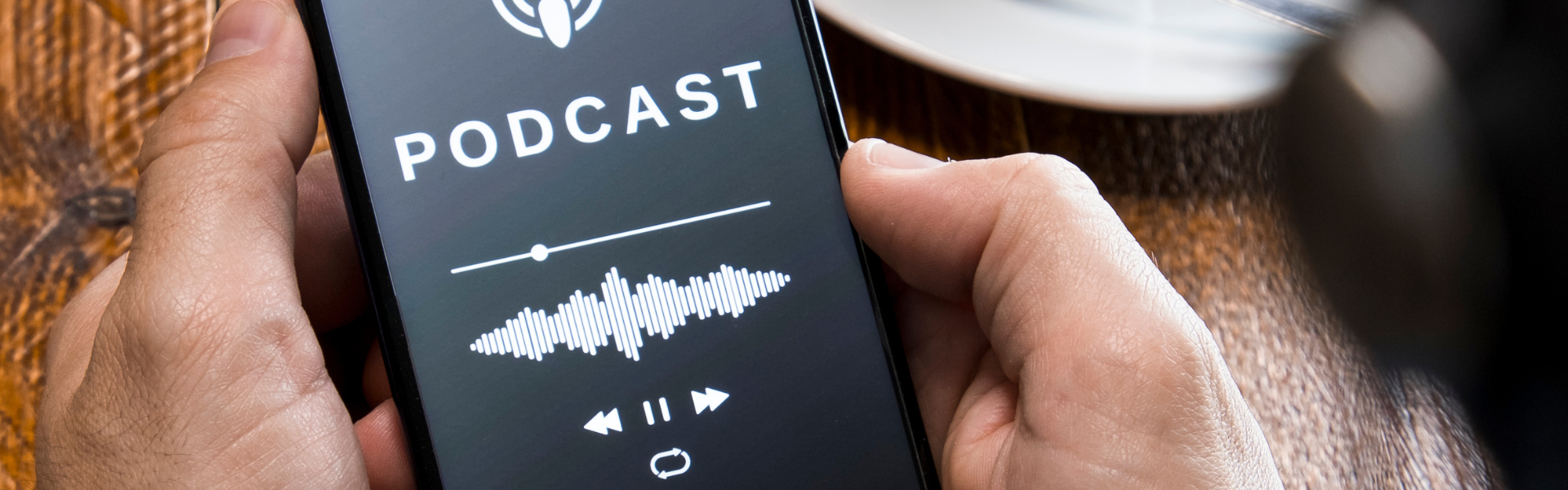 Man holding phone with screen displaying podcast playing info