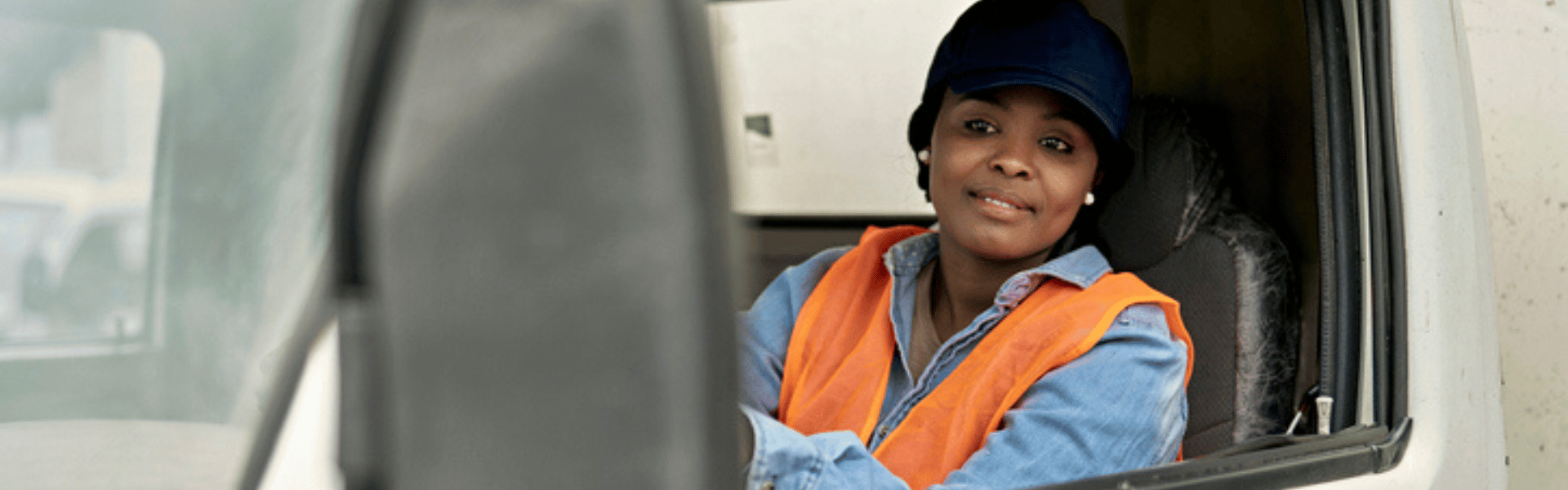 woman looking in sideview mirror of semi truck