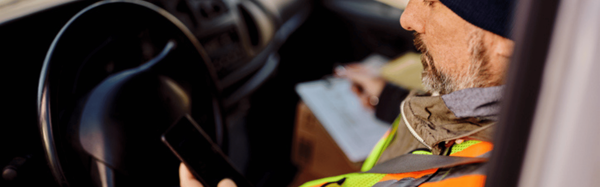 trucker looking at phone in truck
