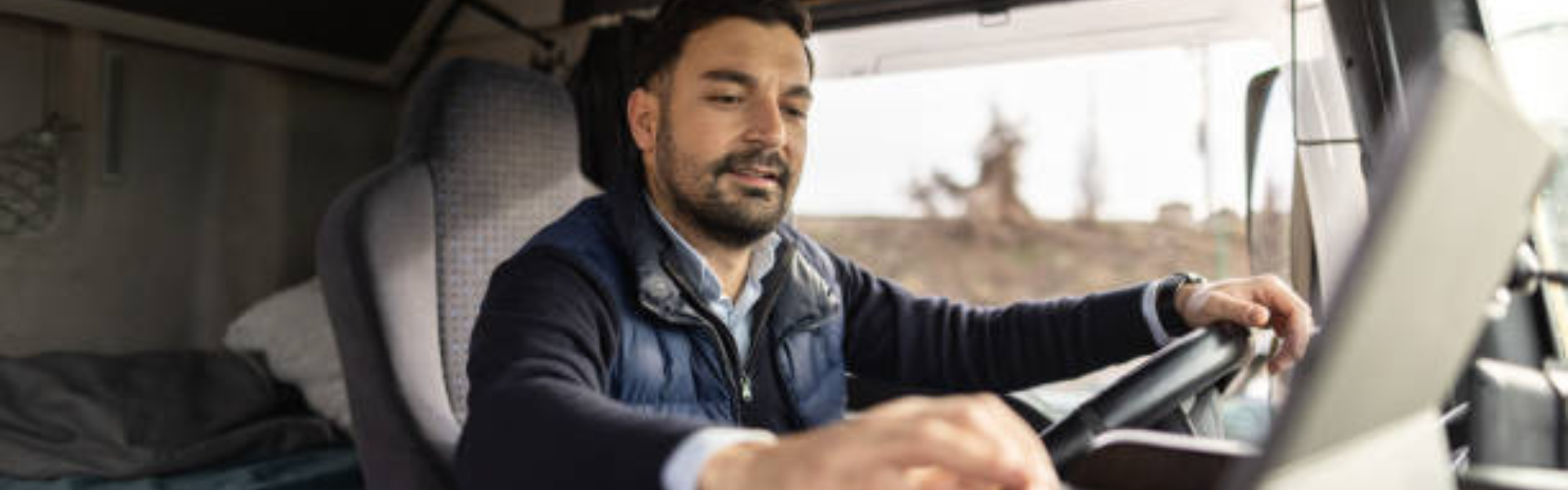 trucker in cab looking at laptop