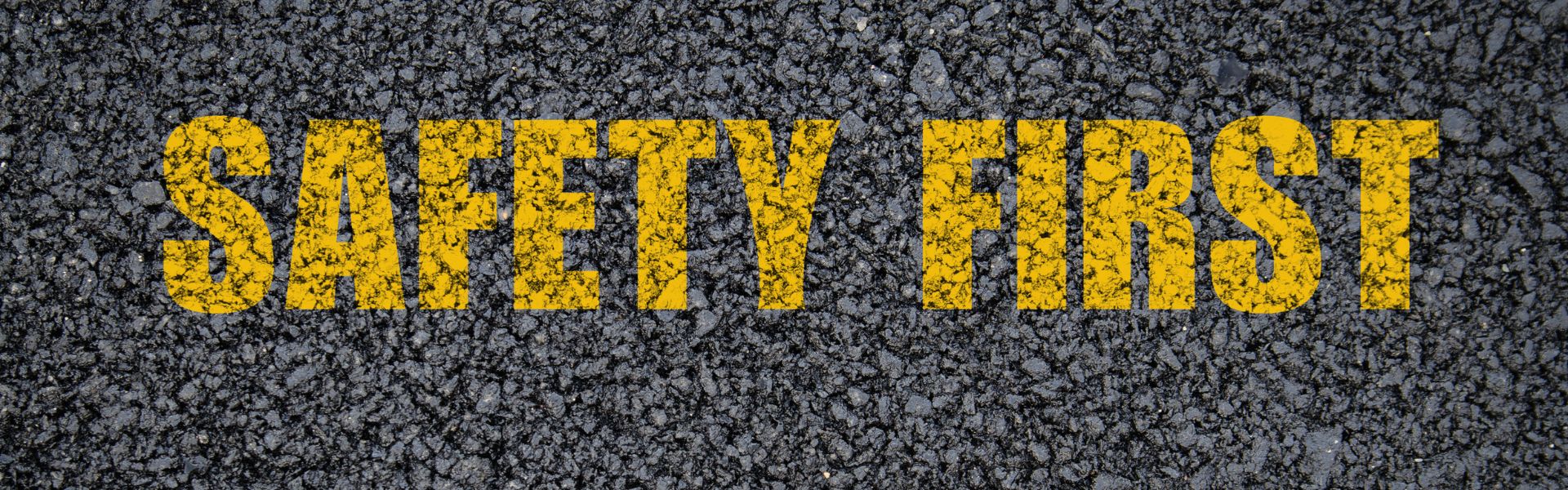 Road with yellow painted words reading safety first