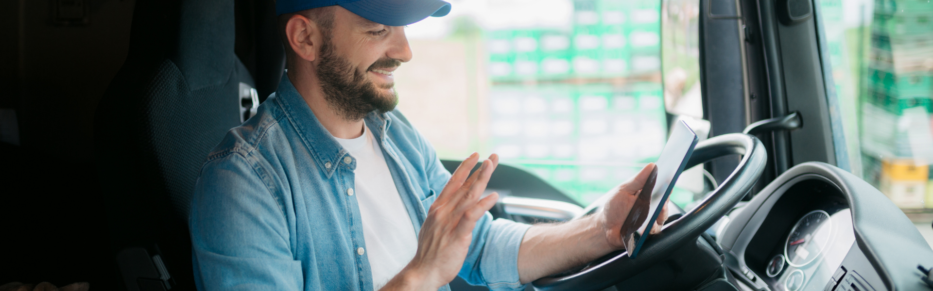 Trucker sitting in cab using tablet for video call