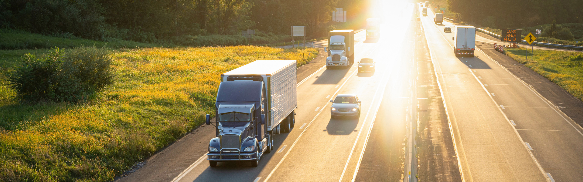 semi trucks on highway at sunset