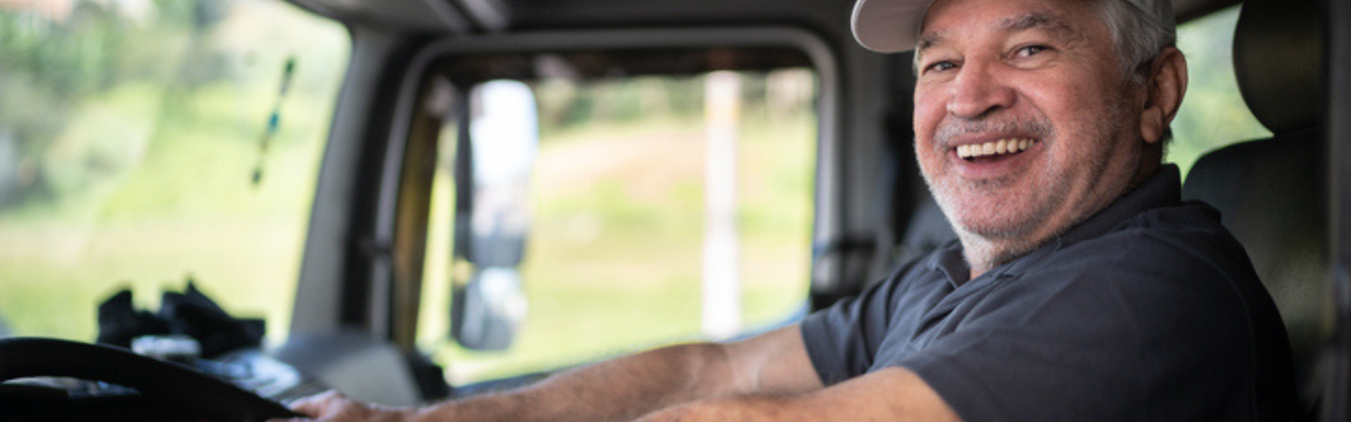 trucker smiling in cab of semi truck