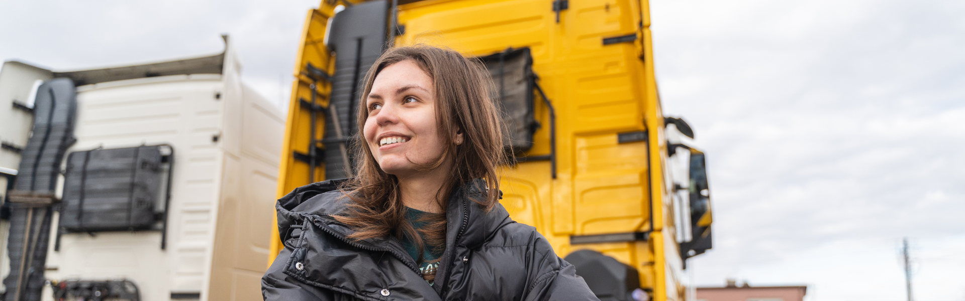 Woman standing in front of semi trucks