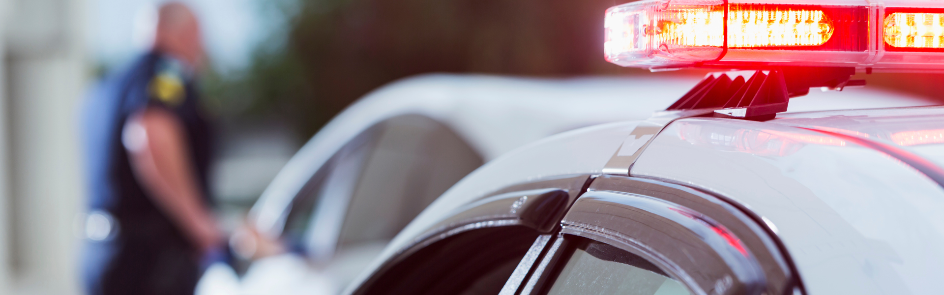 police officer with someone pulled over on side of road. police car with lights on