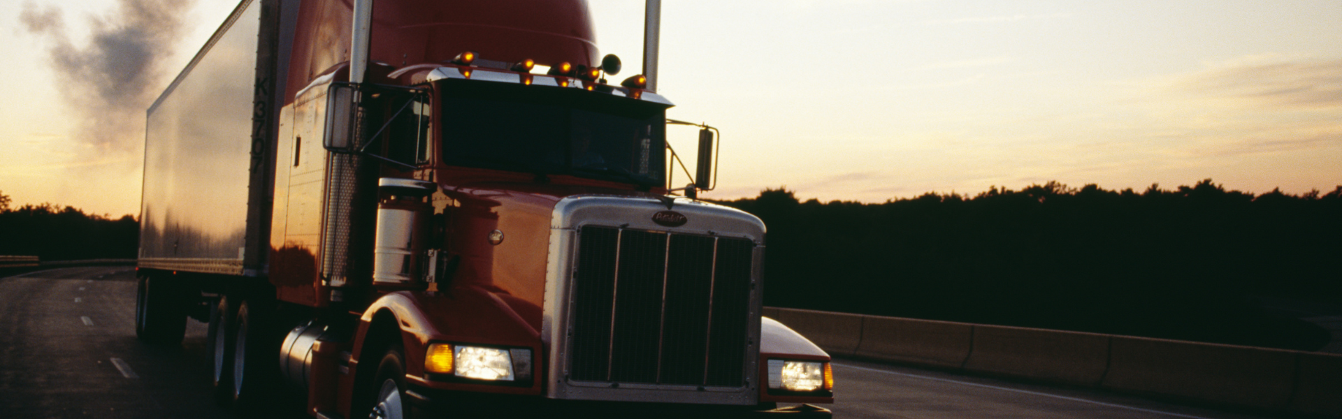 Semi truck on the road at sunset