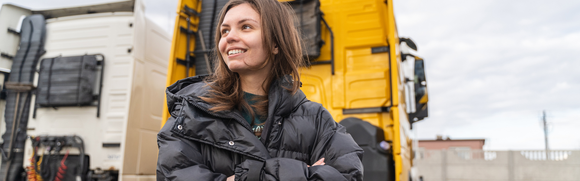 young woman standing in front of semi truck