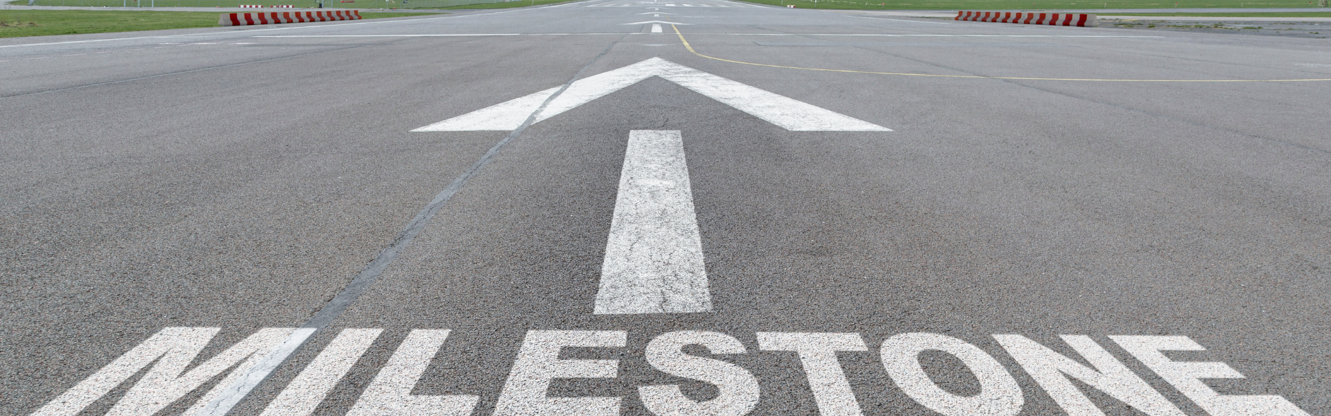 milestone with arrow painted on pavement