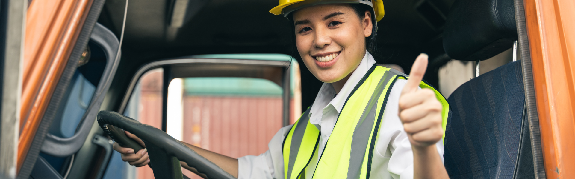 woman sitting behind the wheel of a semi truck