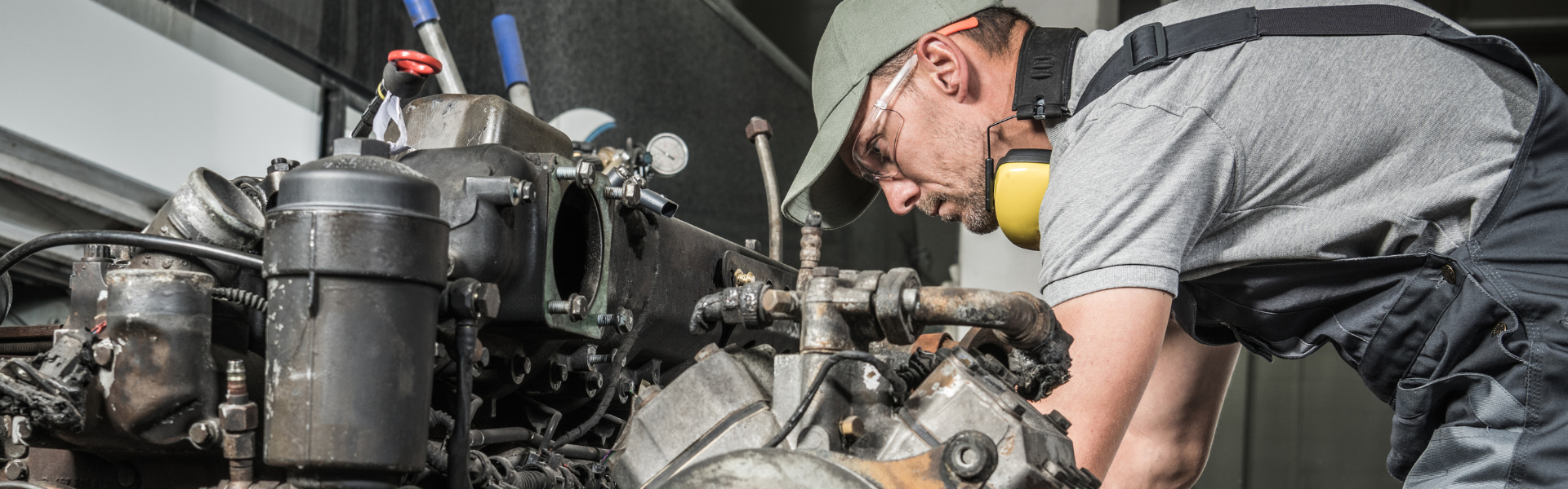 diesel technician leaned over diesel engine