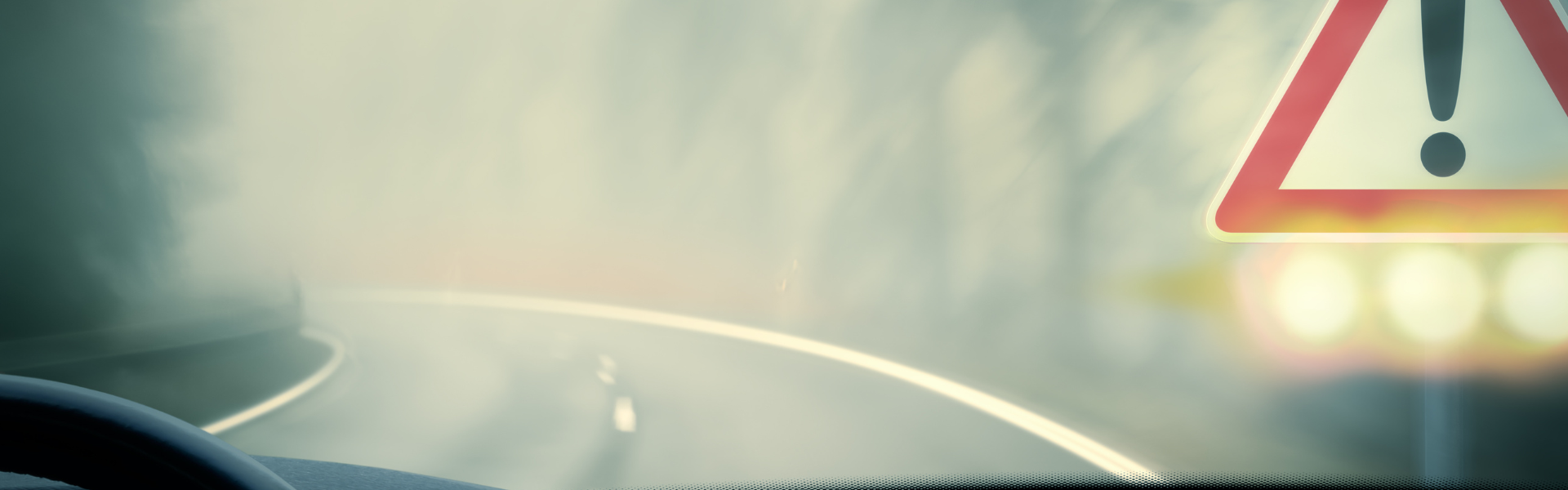 semi truck driving on foggy road with alert in corner of windshield