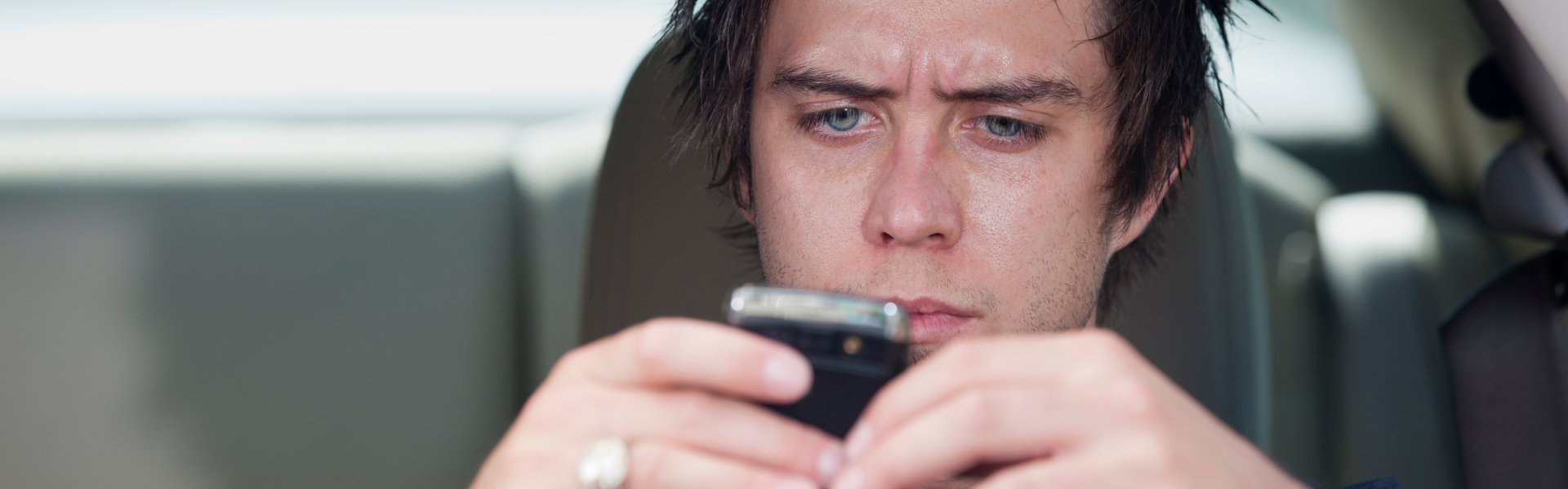man looking at phone while driving