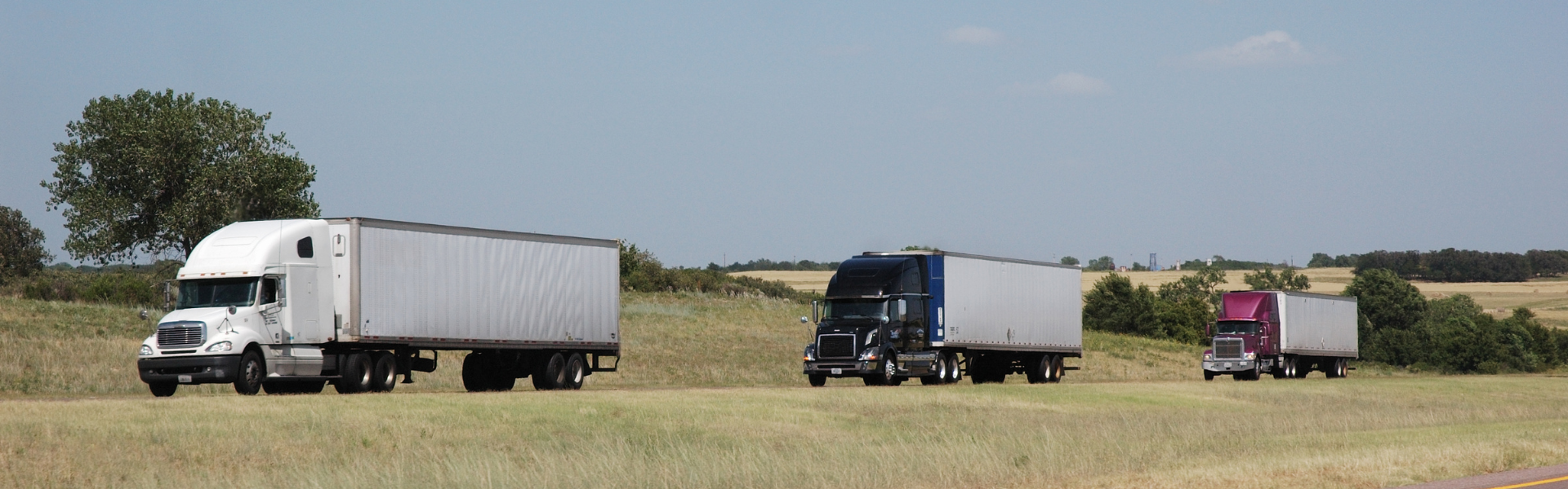 line of semi trucks on road