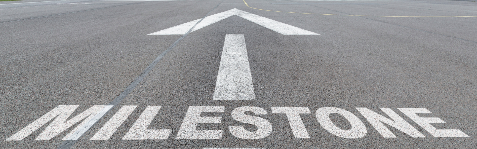 road painted with the word milestone and an arrow