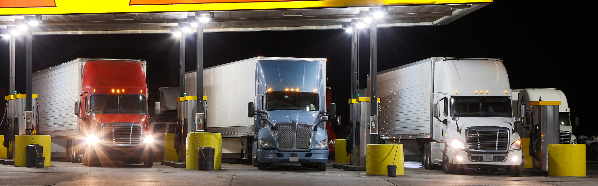 truck stop fuel island at night with semi trucks