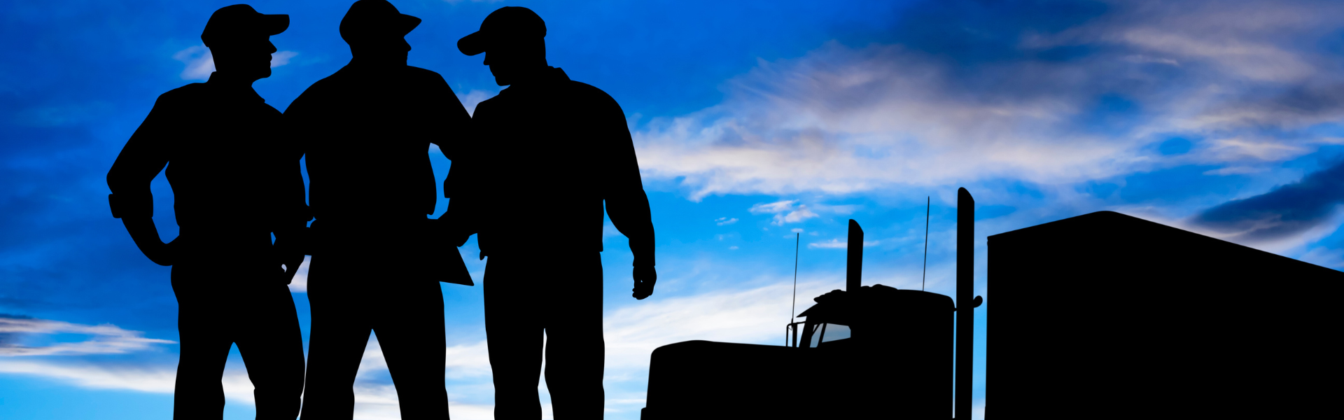 silhouette of men and semi truck