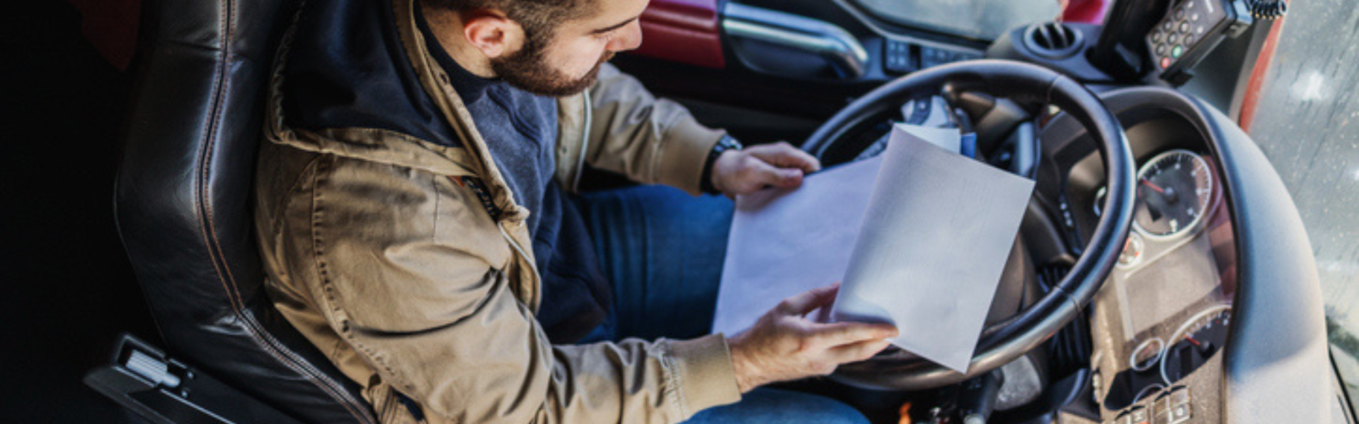 trucker in truck cab with paperwork
