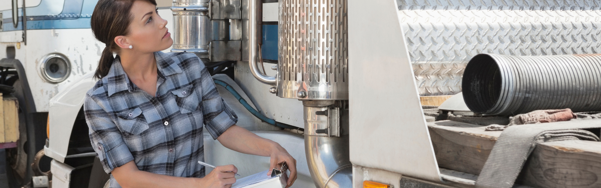 woman with clipboard next to semi truck