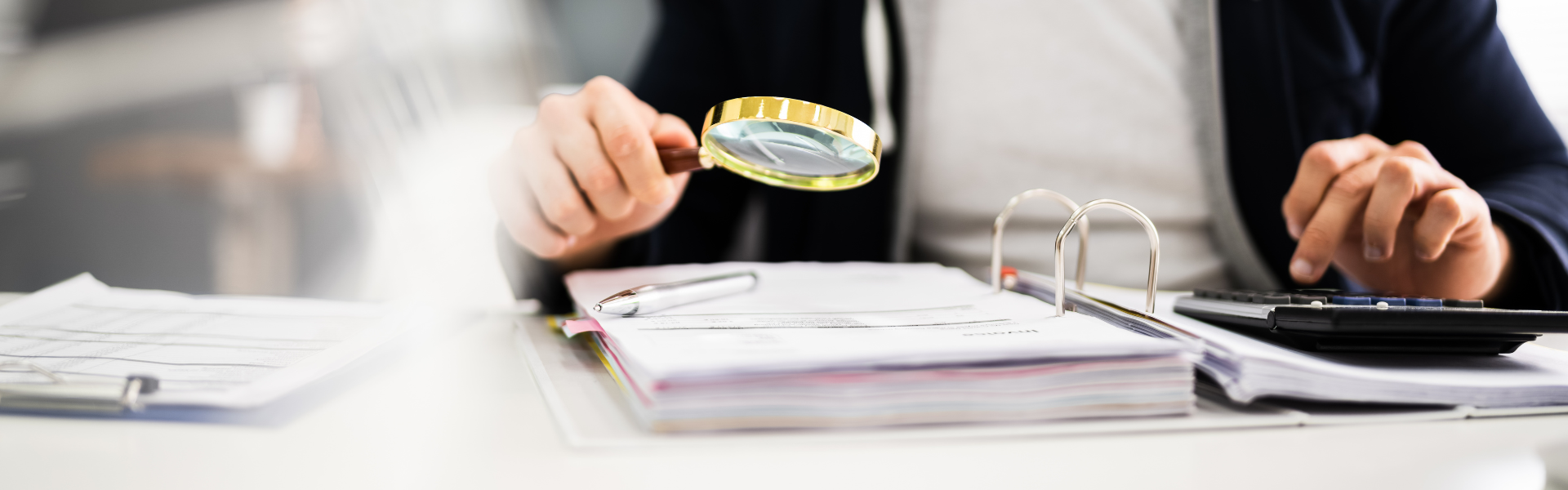 magnifying glass looking over paperwork