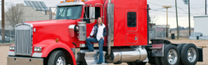 woman standing in door of red semi truck