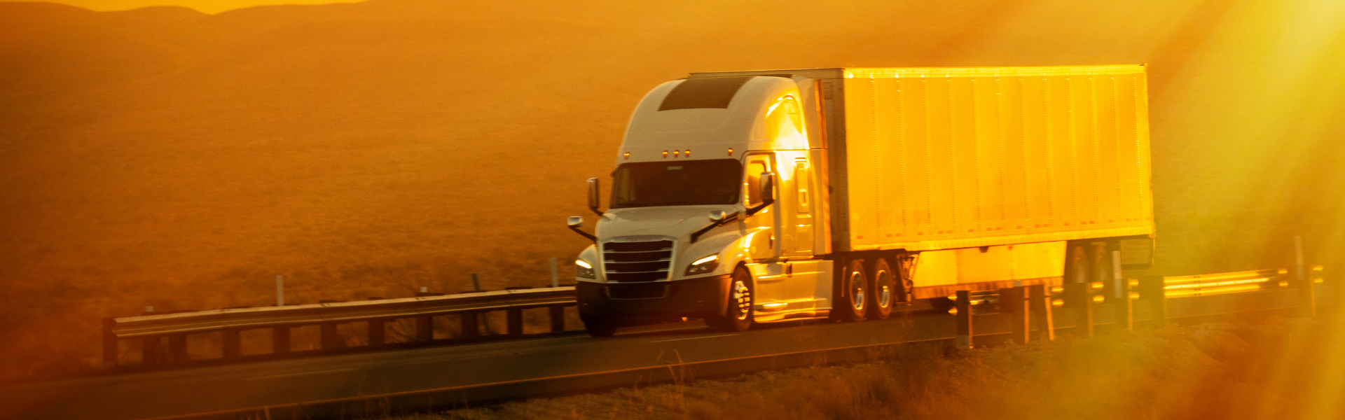 semi truck driving at sunset
