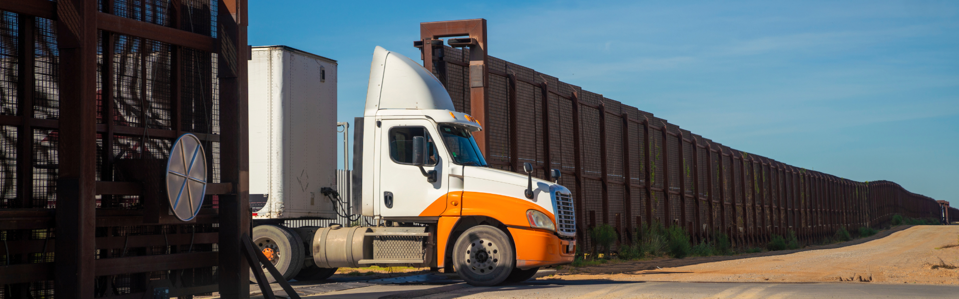 semi truck emerging from border wall