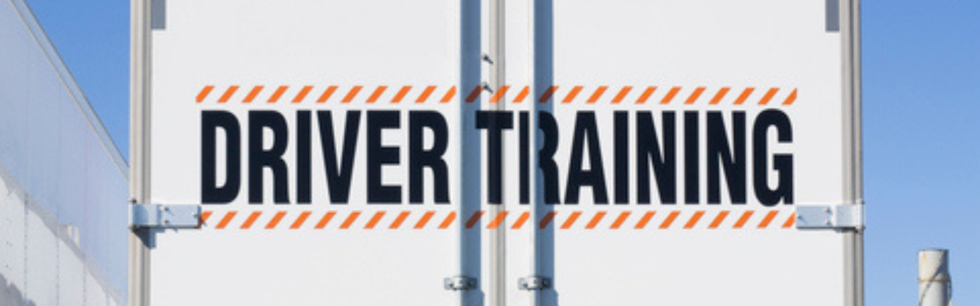 back of semi truck trailer that reads "driver training"