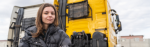woman standing in front of yellow semi truck