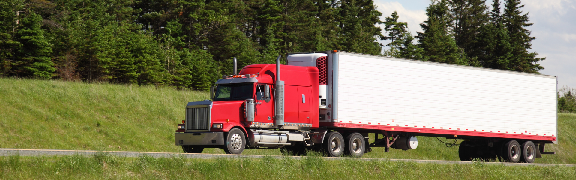 red semi truck with white trailer on road