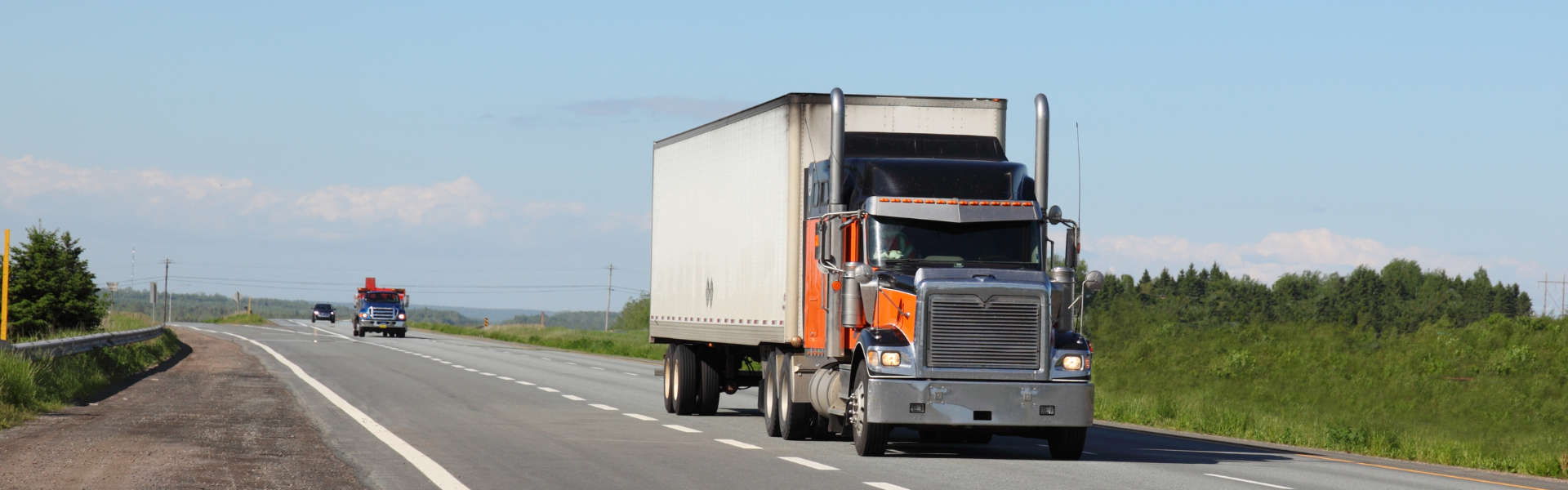 orange and navy semi truck on road