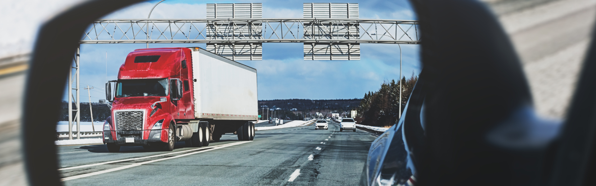 semi truck reflection in car side view mirror