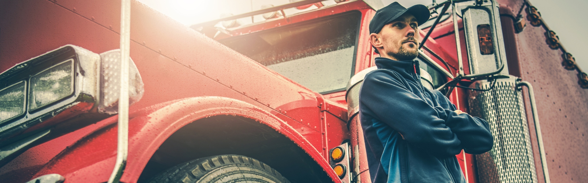 man standing next to red semi truck