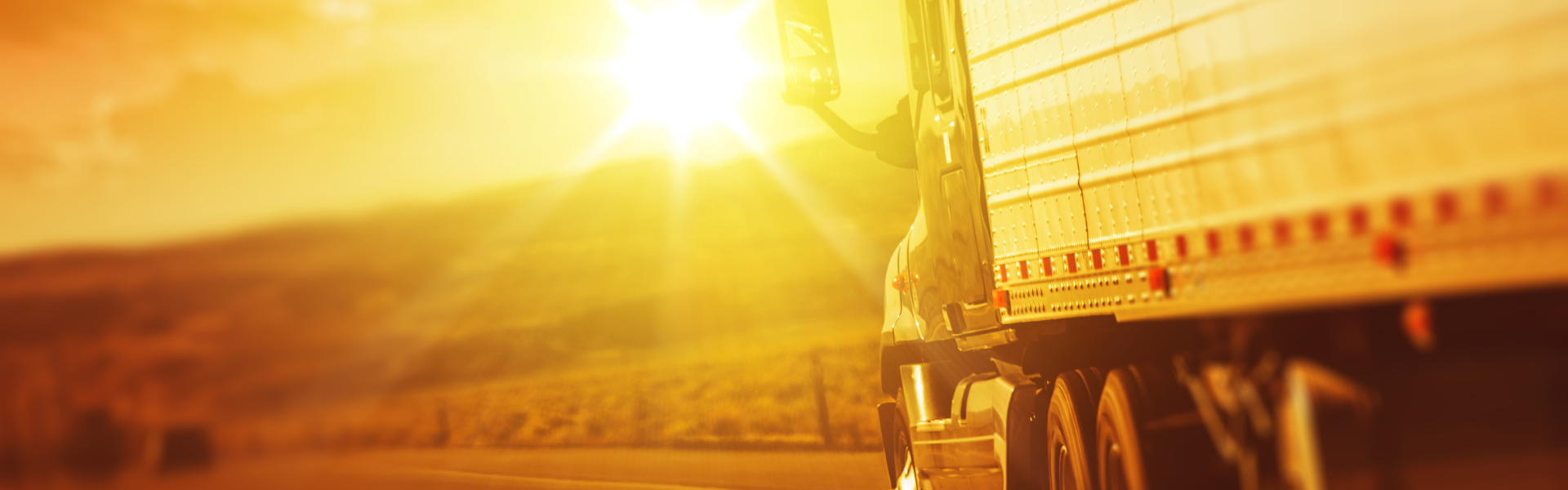 semi truck driving into sunset