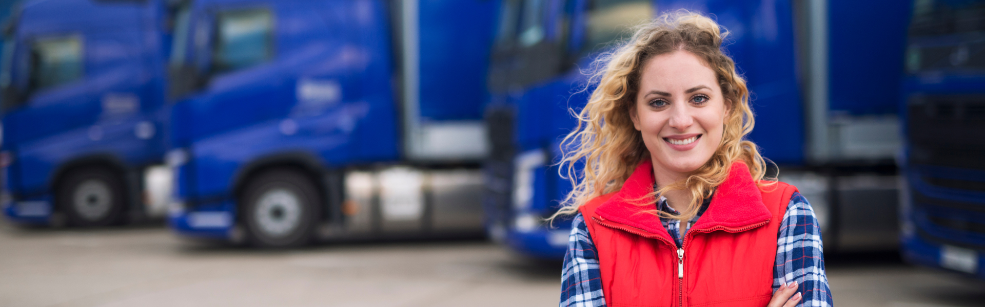 woman standing in front of parked semi trucks
