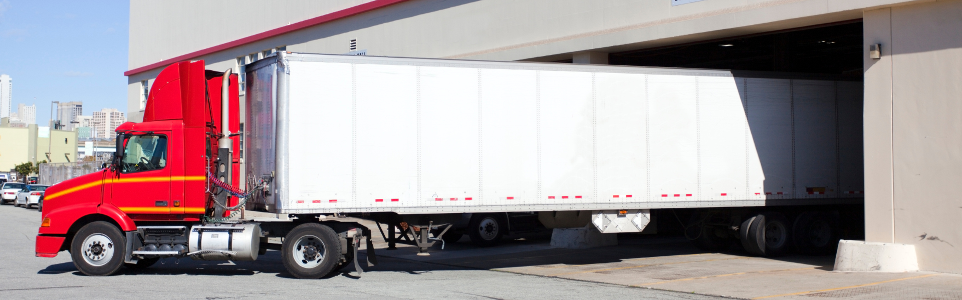 red semi truck backed into loading dock