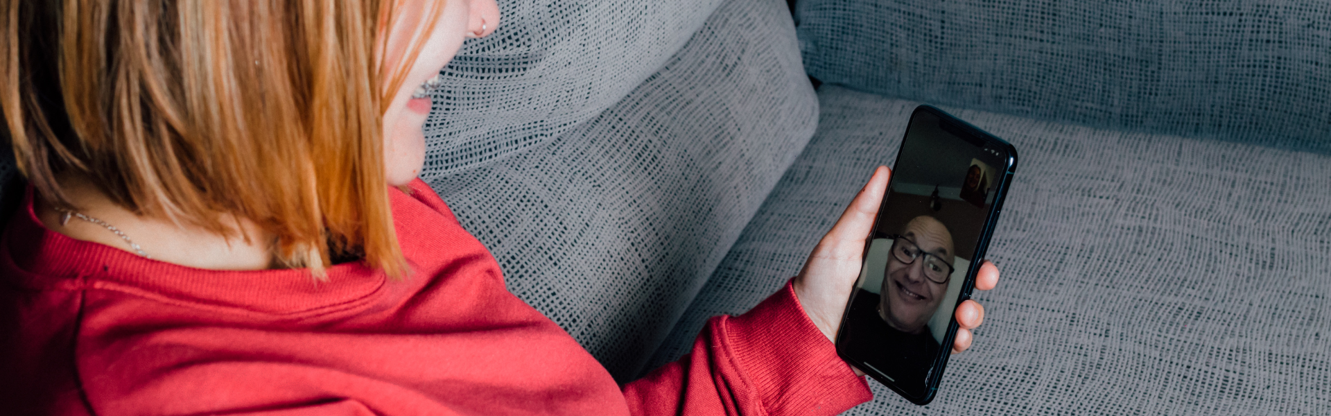 woman sitting on couch talking to man on facetime