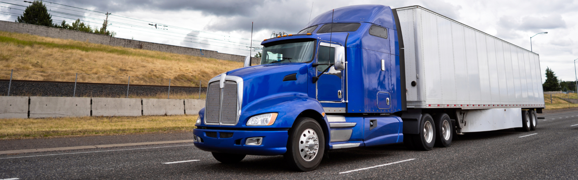 blue semi truck with white trailer with under guards