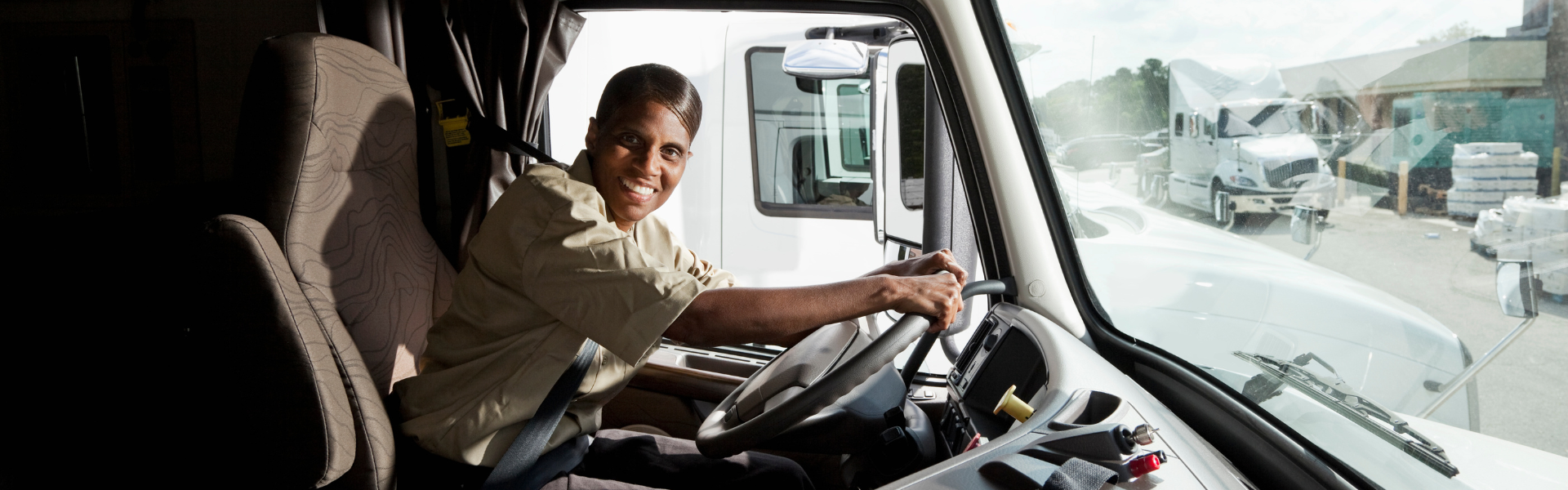 smiling black woman driving semi truck