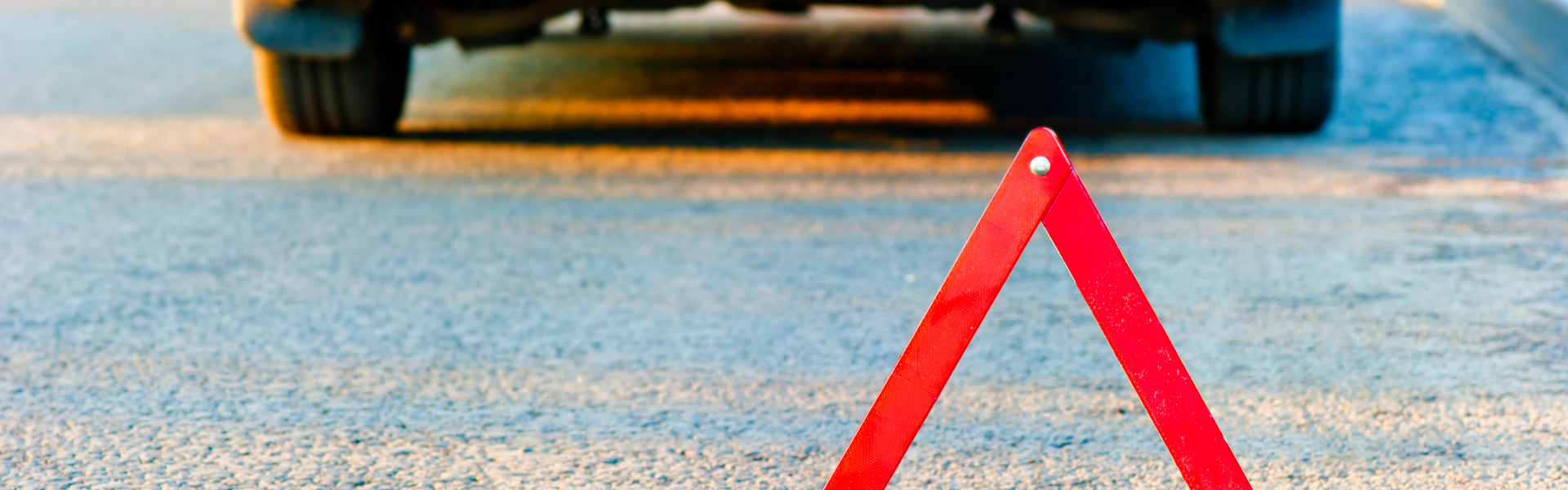 Car pulled over with red caution triangle behind the vehicle