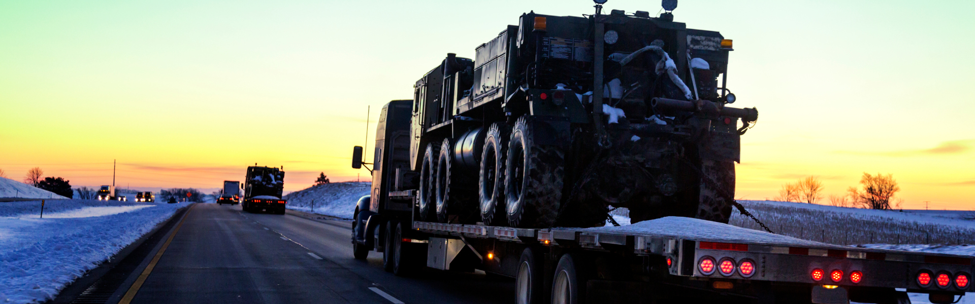 flatbed semi truck driving into sunset