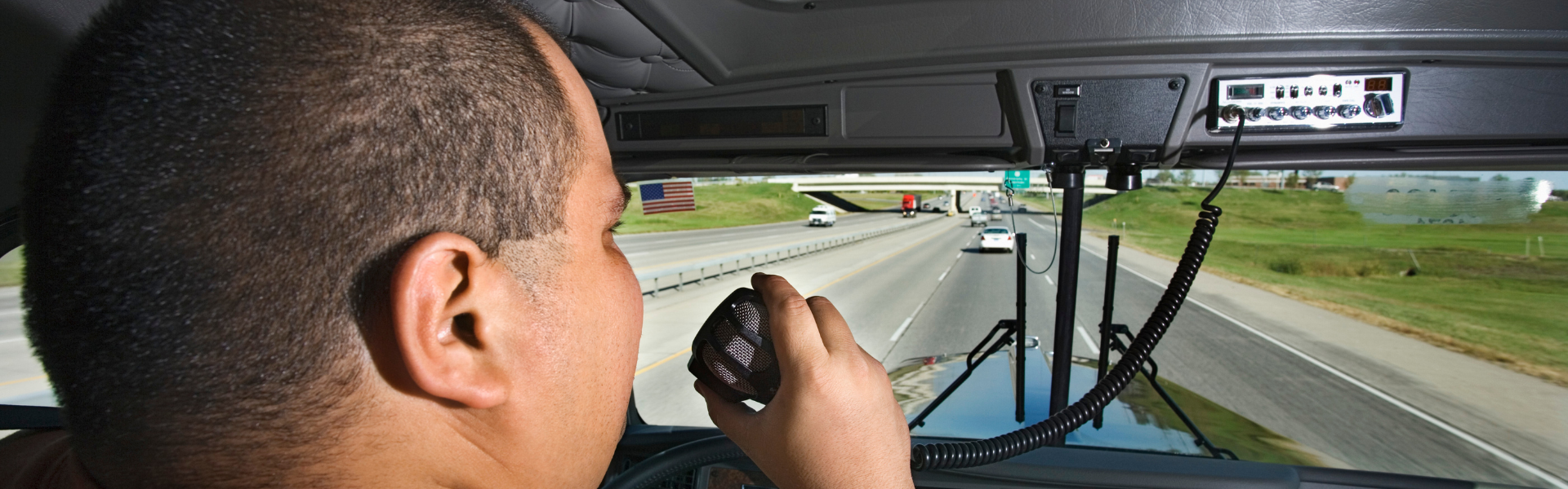 truck driver in cab talking on cb radio