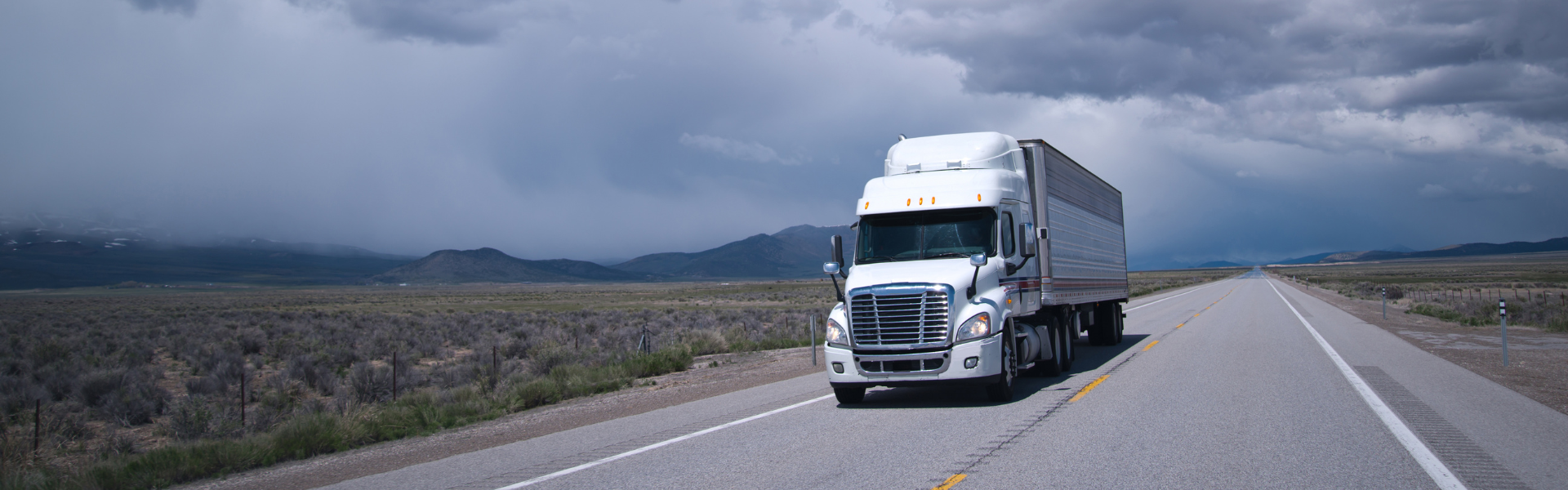 white semi truck on road on cloudy day