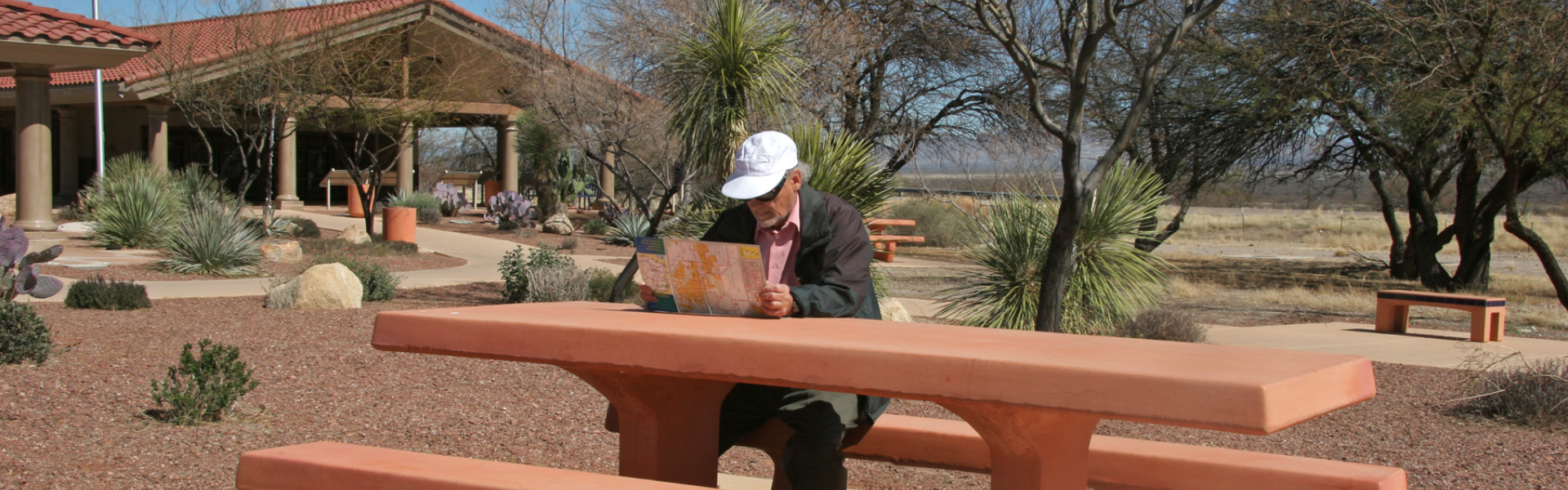 man sitting at picnic table at rest stop