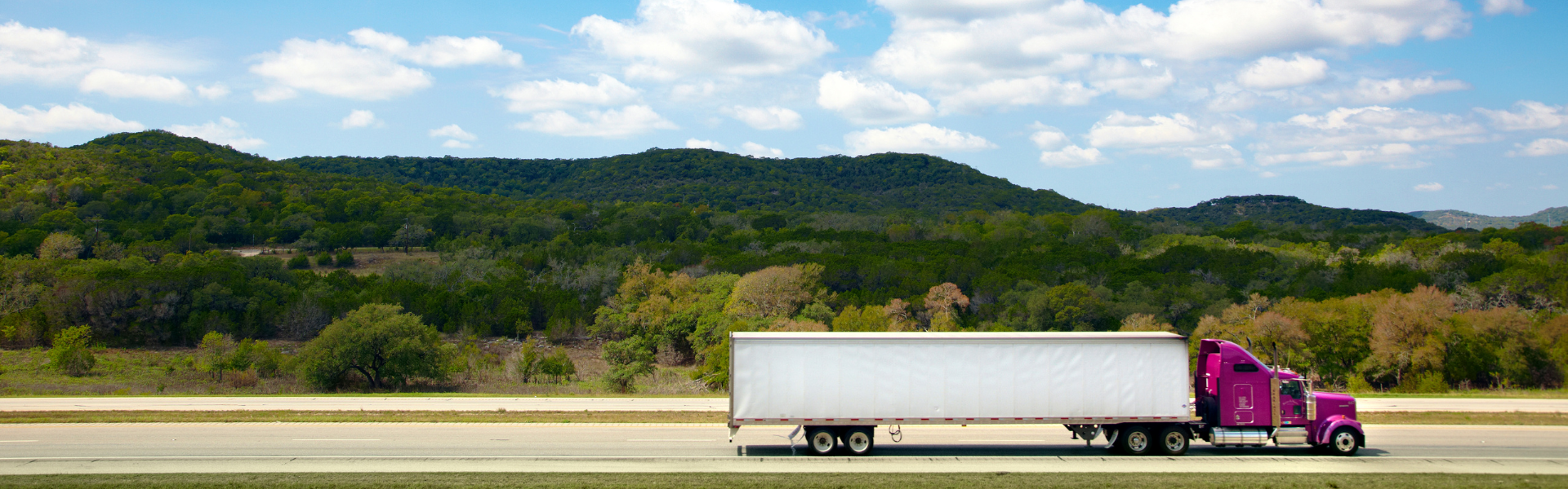 red semi truck with white trailer on road